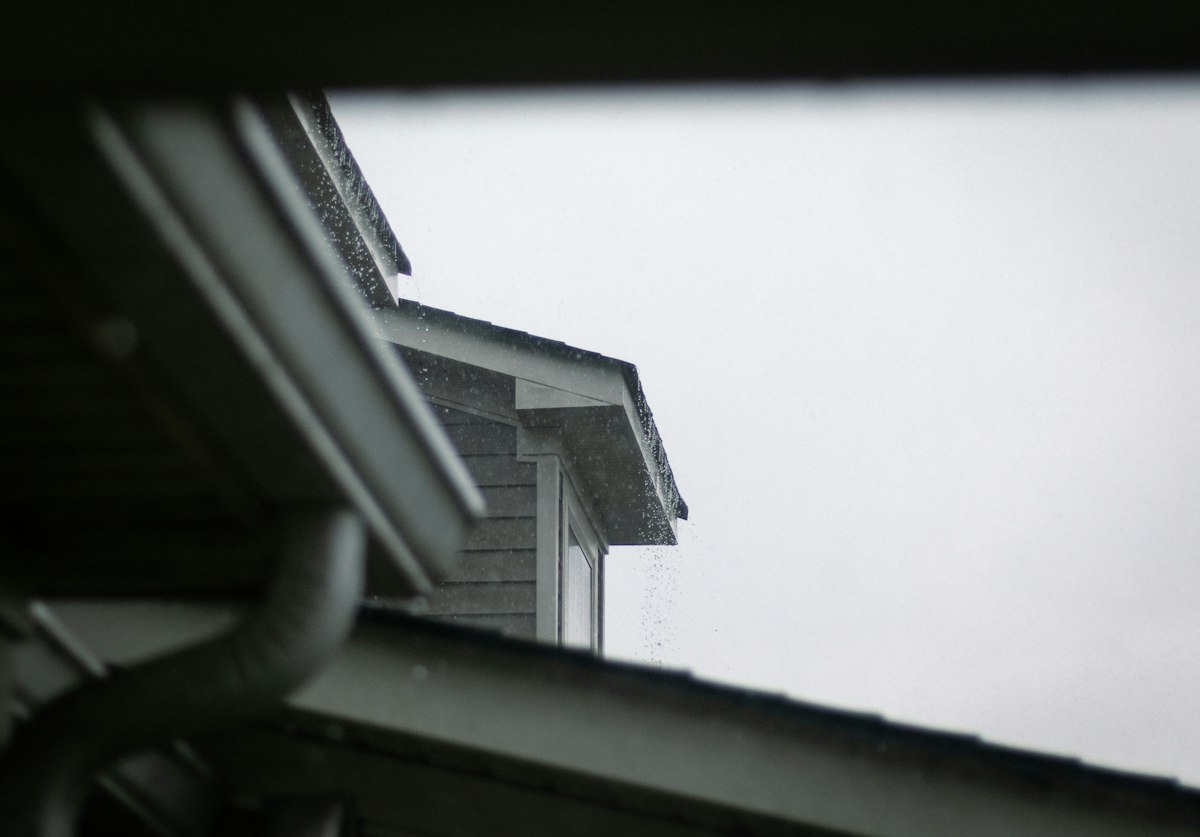 Gutter and downspout along a roofline